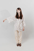 Load image into Gallery viewer, Woman wearing a white and blue printed Hapi, belted at the waist.
