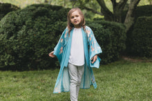 Load image into Gallery viewer, Child wearing a blue floral kimono standing in a garden
