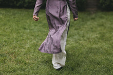 Load image into Gallery viewer, Photo of close up of lower portion of tunic and pants.  Woman is walking and tunic is flowing up with movement showing pants under and slit opening of tunic to the waist.
