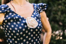 Load image into Gallery viewer, Close up photo of the neckline and rosette on the front of the dress.  Photo shows cap sleeves and front seams of the bodice of the dress.
