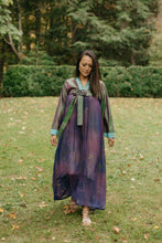 Load image into Gallery viewer, Woman wearing a purple shot silk han bok dress and jacket.  Jacket is of teal and green shot silk and tied in the front.  Woman is walking in a lawn with shrubs in the background.
