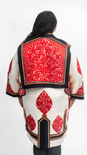 Load image into Gallery viewer, Back view of the szur with decorative red cut felt work over black and white felt coat.
