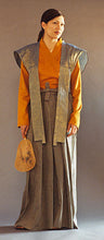 Load image into Gallery viewer, Photo of woman wearing Hakama pants with Kataginu.  Woman is holding a fan in her right hand.
