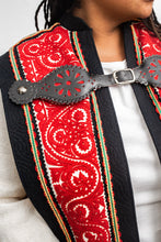 Load image into Gallery viewer, Close up of the cut feltwork of the szur - black, red, and white.  With the decorative leather buckle.
