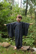 Load image into Gallery viewer, Boy standing outdoors in a forest in  a dark blue kimono with trees and greenery in the background
