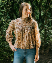 Load image into Gallery viewer, Brunette woman standing surrounded by greenery with hand on her hip looking to the right, wearing 205 Gibson Girl Blouse.
