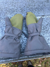 Load image into Gallery viewer, Pair of grey mittens with green hand grips on a piece of sheet metal outside.
