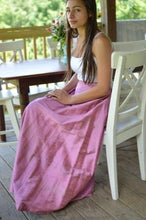 Load image into Gallery viewer, Young Brunette woman sitting at a dinning table outside with hands on her lap wearing a white spaghetti strapped shirt and 209 Walking skirt.
