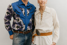 Load image into Gallery viewer, A man and a older woman standing in front of a white studio backdrop ,wearing 212 Five Frontier Shirts. Man wearing View D with decorative bull's head yoke and woman wearing View A with lace up front with belt around the waist.
