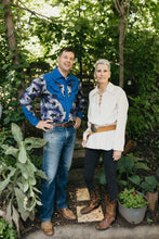 Load image into Gallery viewer, Man and an older woman standing in a pathway surrounded by greenery both wearing 212 Five Frontier Shirts. Man is wearing  View D with decorative bull's head yoke, woman is wearing View A with lace up front and a belt around the waist.
