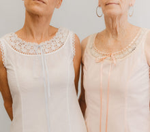 Load image into Gallery viewer, Close up of the top of two slips with lace at the necklines.
