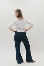 Load image into Gallery viewer, Back view of woman standing with both hands on hips, head turned to the side, wearing 229 Sailor pants and a white long sleeve.
