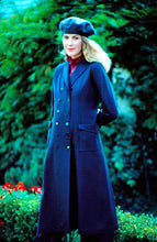 Load image into Gallery viewer, Woman standing surrounded by greenery wearing 230 Model T Duster with hands behind her back and a beret.
