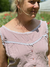 Load image into Gallery viewer, close up of middle aged blonde woman wearing a sleeveless camisole in pale pink with white ruffle lace.
