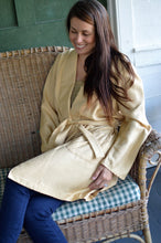 Load image into Gallery viewer, Brunette woman sitting on a woven chair legs crossed wearing 238 Le Smoking Jacket with sash wrapped around her waist.

