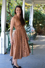 Load image into Gallery viewer, Woman wearing a brown polka dot blonde bombshell dress on a covered porch.
