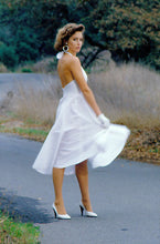 Load image into Gallery viewer, Woman wearing a white blonde bombshell dress on a road while twirling. She is wearing white kid gloves.

