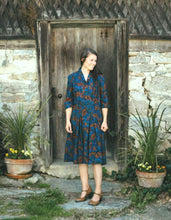 Load image into Gallery viewer, Woman standing in front of a old wooden door and a stone pathway wearing 247 Lindy Shirtdress
