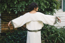 Load image into Gallery viewer, Young Brunette White woman wearing the Greek Island Dress with Jacket, showing the back view of the Dress with jacket, extending both arms showing the center back godet that adds flare.
