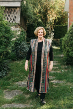 Load image into Gallery viewer, Woman walking outdoors in panel coat.  Coat is made with woven Ikat fabric.
