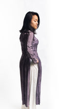 Load image into Gallery viewer, Side view of Vietnamese American woman wearing a purple silk Ao Dai tunic with white pants.
