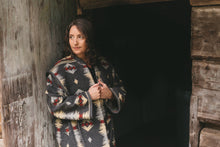 Load image into Gallery viewer, Photo of woman wearing Hungarian Szur view B with hands at front showing finished hems on sleeves.
