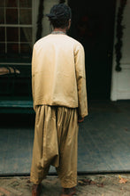 Load image into Gallery viewer, Person wearing a gold Algerian Suit standing in front of a door, with back to the camera.
