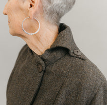 Load image into Gallery viewer, Older white woman wearing sliver hooped earnings ,close up of her left shoulder and neck wearing the Traveling Jacket buttoned on the left side on the neck, with a contrast over collar
