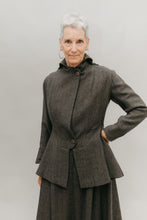 Load image into Gallery viewer, Older white woman with gray hair with her left hand on her hip, standing in front of a white studio backdrop wearing the traveling suit buttoned
