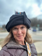 Load image into Gallery viewer, Woman wearing a black roll brim hat outside.  Hat has an overlap with corner on brim.
