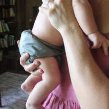 Load image into Gallery viewer, close up of baby in a cloth diaper in moms arms
