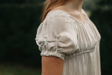 Load image into Gallery viewer, Close up of the sleeve of 215 Empire Dress with short puffed sleeves with cord detailing.
