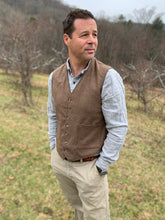Load image into Gallery viewer, Man standing in a field turned slightly to the left looking right, wearing View A of 222 Vintage Vests collarless but with two pockets.
