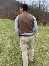 Load image into Gallery viewer, Back view of man walking in a field wearing 222 Vintage Vests with no adjustable waist belt in the back.
