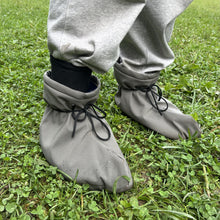 Load image into Gallery viewer, Gray shoe covers worn on feet standing on grass
