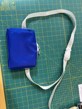 Load image into Gallery viewer, Blue bag with a white strap on a green cutting mat
