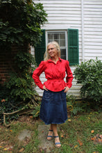 Load image into Gallery viewer, Bright red calico day dress shirt on a woman in a denim skirt in front of a white house.
