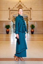 Load image into Gallery viewer, Young blonde woman standing in a lobby wearing the Metropolitan Suit holding black gloves in her right hand and brown heeled boots on her feet.
