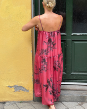 Load image into Gallery viewer, Woman wearing a pink floral dress standing in front of a yellow wall and green door.

