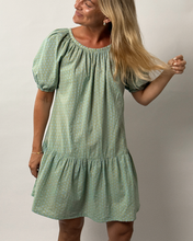 Load image into Gallery viewer, Woman wearing a green dress against a plain background
