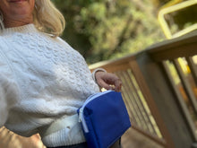 Load image into Gallery viewer, Person wearing a white sweater holding a blue bag outdoors
